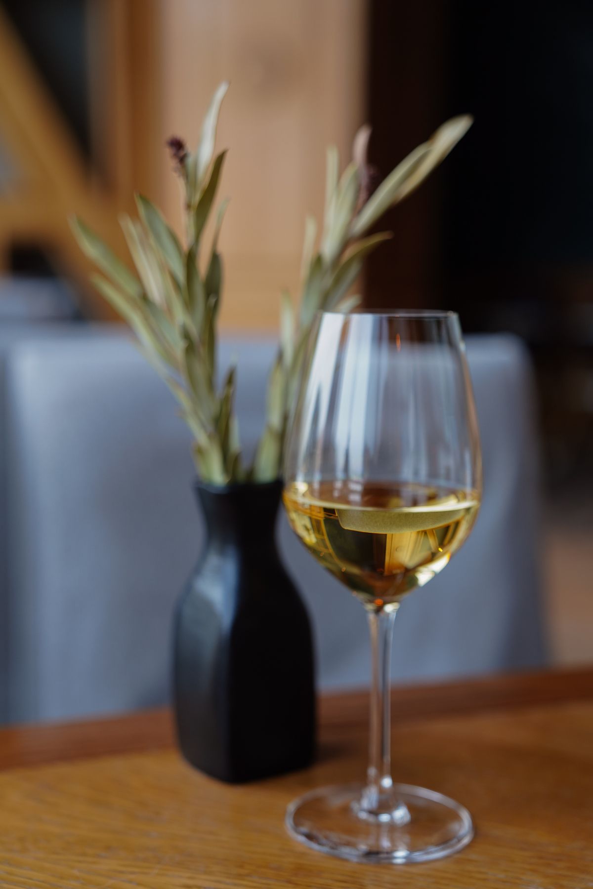 A glass of white wine on a restaurant table