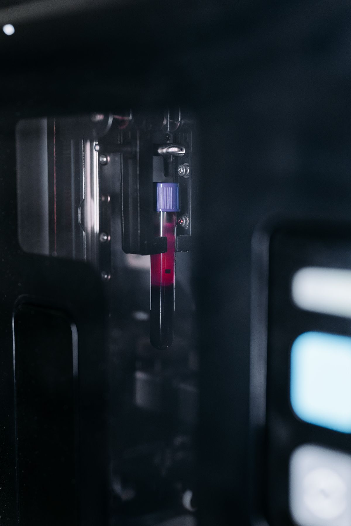 A blood sample tube held inside a laboratory analyser