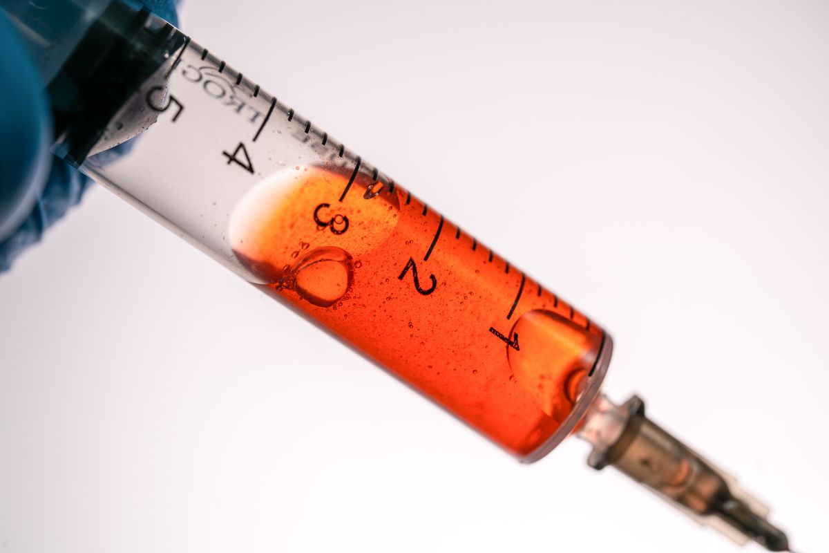 A syringe held against a white background
